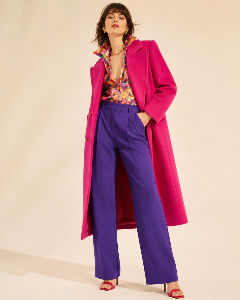 Woman in a fuchsia tailored coat with violet trousers